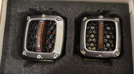 Two LED light modules in a protective foam packaging on a gray surface.