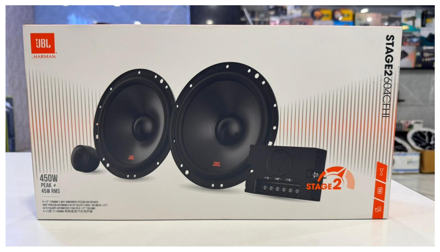 JBL speaker system packaging on a white surface with a blurred background