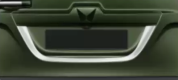 Close-up of a green vehicle's grille with a logo