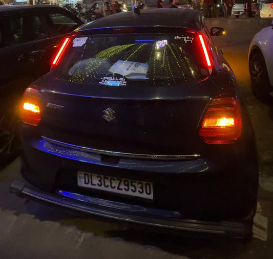 Black car with illuminated rear lights on a dark street