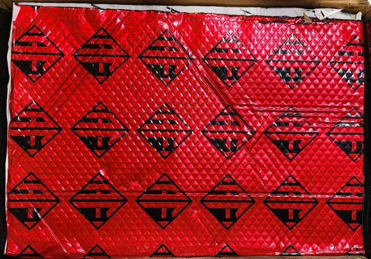 Red quilt with black geometric patterns on a white background