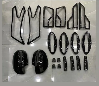 Set of black car accessories including grills and covers on a white background