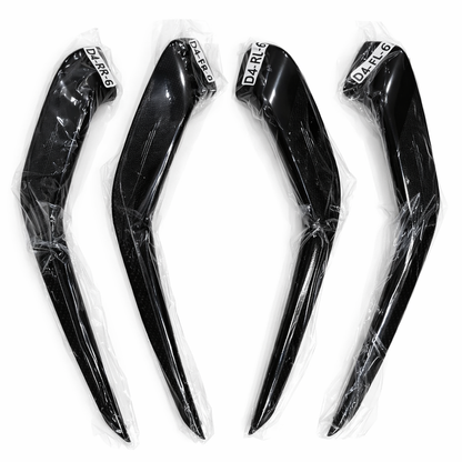 Four black motorcycle fairing panels with clear plastic wrap on a white background