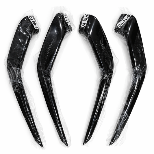 Four black motorcycle fairing panels with clear plastic wrap on a white background
