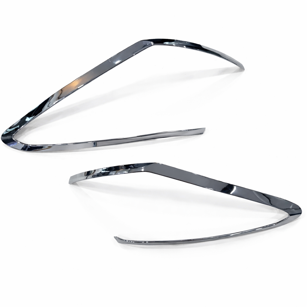 Two chrome car headlight covers on a white background