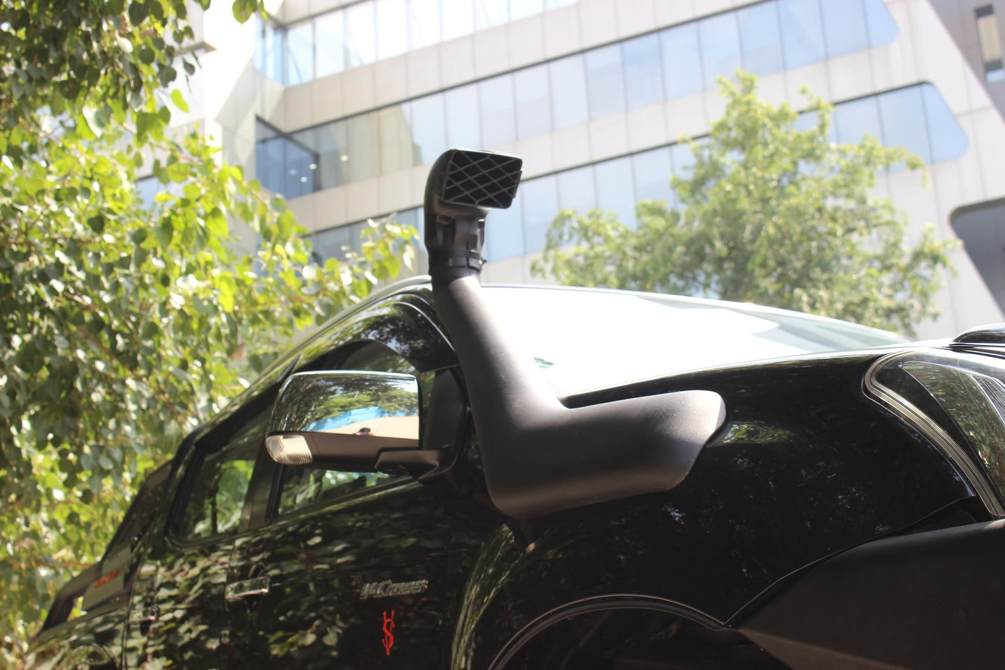 Car with a roof-mounted camera system in an urban setting