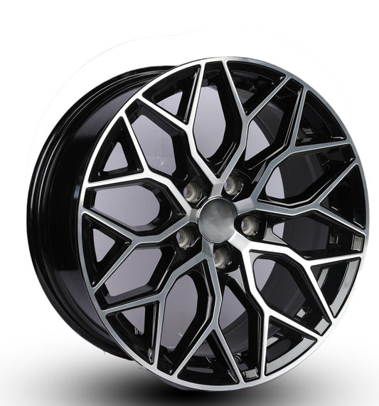 Black alloy wheel with geometric design on a white background