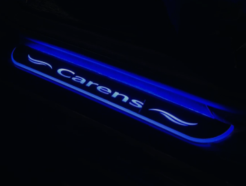 Car door sill with 'carens' branding on a dark background