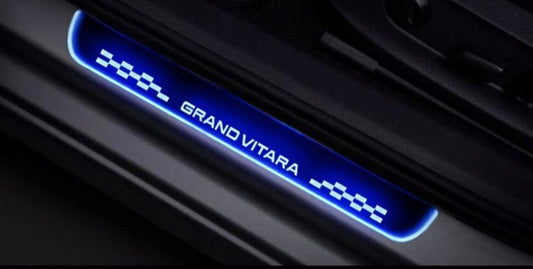 Car door sill with 'Grand Vitara' branding in blue light on a dark background