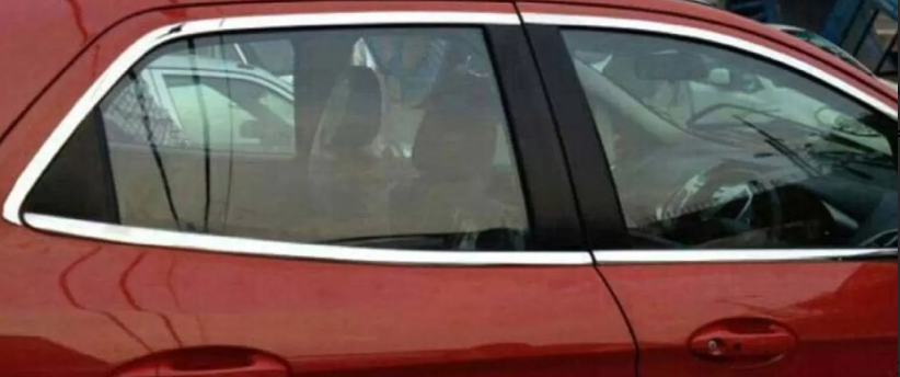 Red car with a person inside, partially obscured by a window shade.