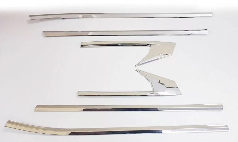 Set of chrome car trim pieces on a white background