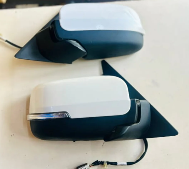 Two car side mirrors, one white and one black, on a light background.