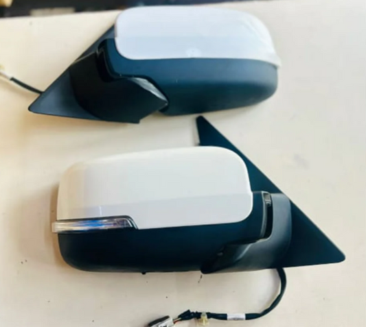 Two car side mirrors, one white and one black, on a light background.