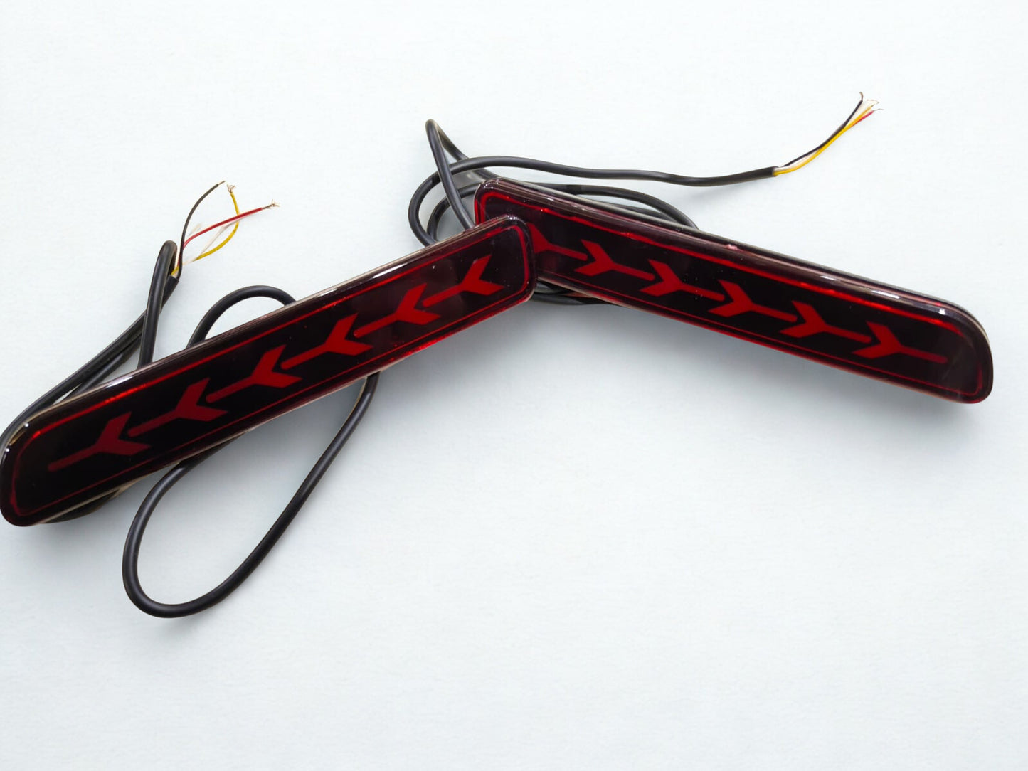 Two car fog lights with red and black design on a white background