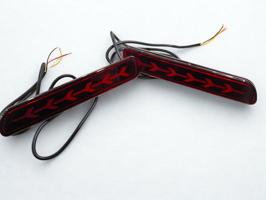Two car fog lights with red and black design on a white background