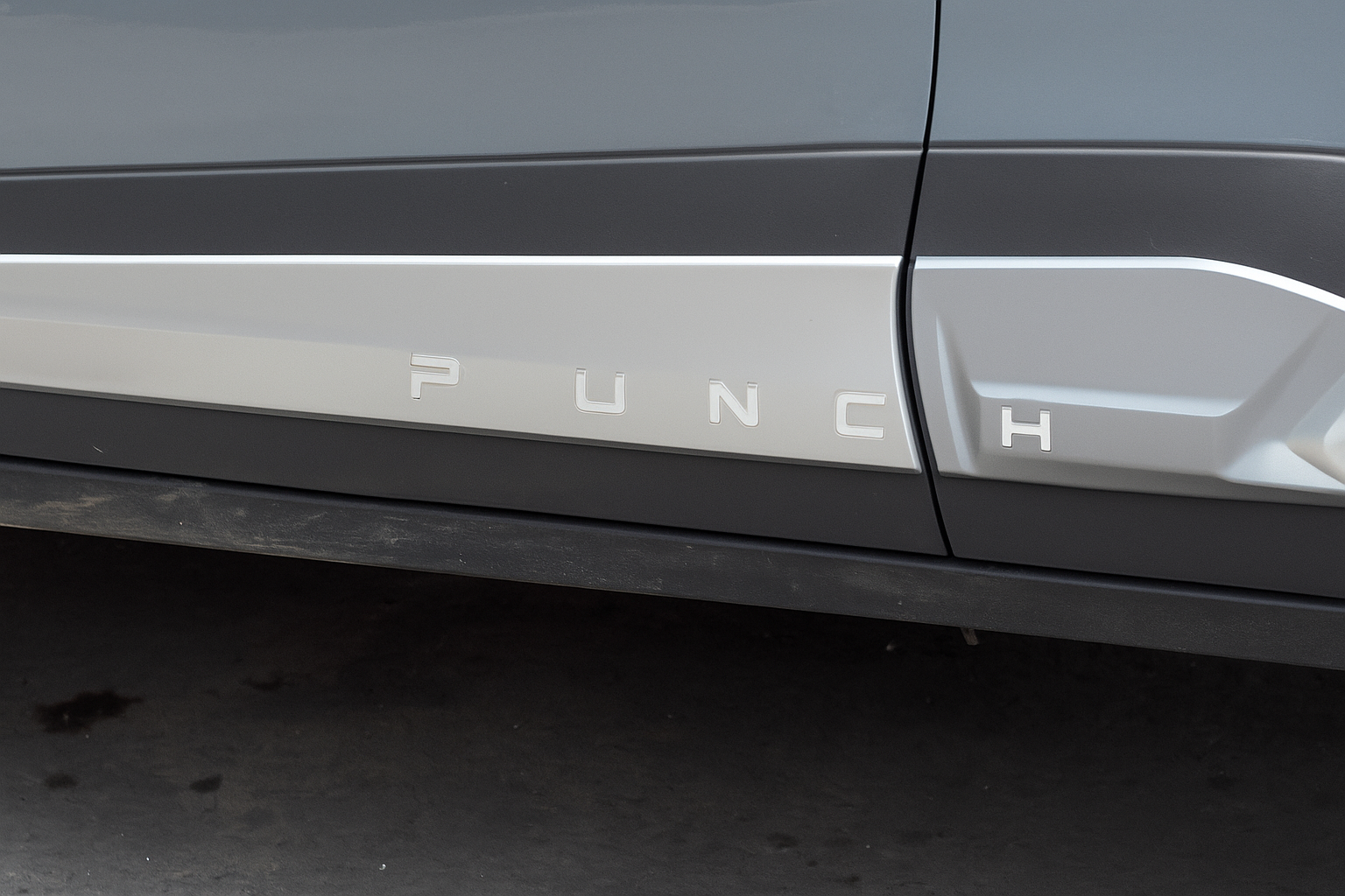 Car door with 'PUNCH' branding on a dark background